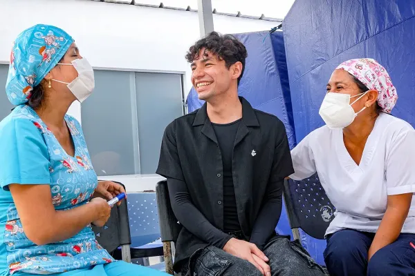 Kioshi Vásquez, middle, with members of his tuberculosis care team at the Carabayllo Health Center in Peru.