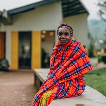 After her appointment, Narame Bernadette sits alone outside the hospital, taking a quiet moment to reflect.