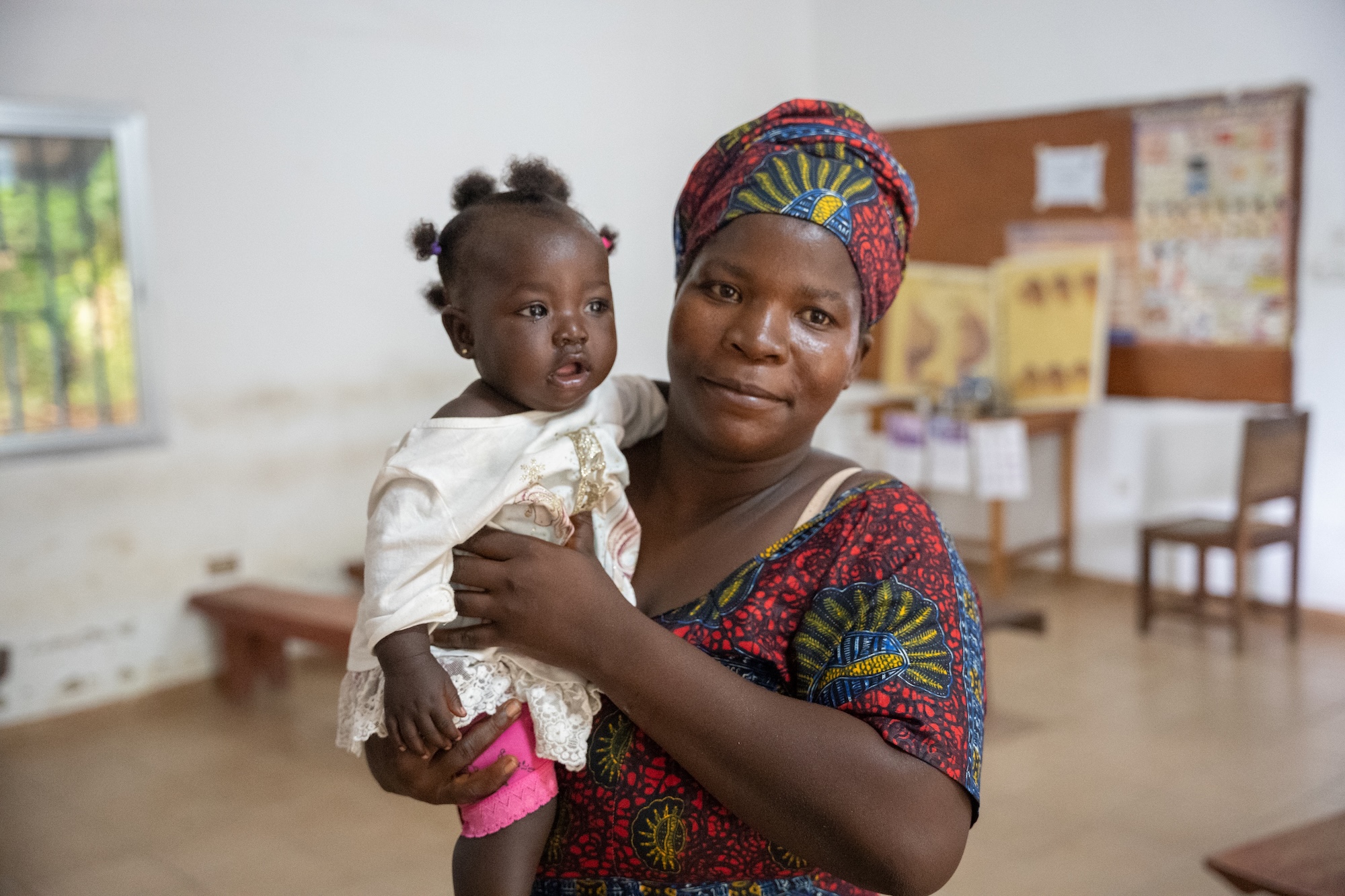 Susan Kamara holds her 6-month-old daughter, Salimatu, at the Wellbody Clinic in Sierra Leone, where she receives a routine check-up and the new malaria vaccine.